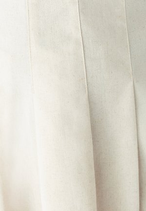 Tela de un beige claro con un acabado texturizado y un diseño plisado. El material parece natural y ligeramente áspero, lo que enfatiza su calidad ecológica.