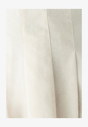 Tissu plissé, blanc cassé, avec une finition naturelle texturée. Le matériau semble doux avec des points subtils, améliorant son apparence organique.
