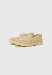 Beige Wildleder Slipper mit glatter Oberfläche, abgerundetem Zeh und minimalistischem Design. Dicke Sohle mit Profil für besseren Halt.