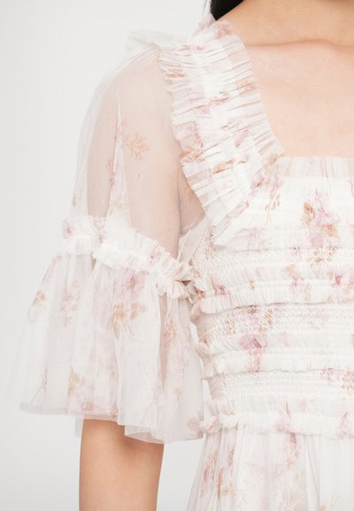 Sukienka w kwiaty z przejrzystymi, falbanianymi rękawami; lekka tkanina w białym kolorze z różowymi i beżowymi kwiatowymi wzorami; karczek z marszczeniami dla tekstury.