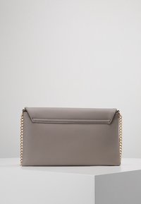 Šedá kabelka z faux kůže s zlatým řetízkem, obdélníkový tvar a přední klopna. Disponuje hladkým povrchem a minimalistickým designem.