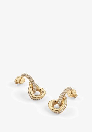 Złote kolczyki w kształcie serca z ozdobnym, skręconym paskiem wysadzanym przezroczystymi kryształami, z polerowanym wykończeniem i tłoczonym logo marki na spodzie.