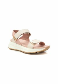 Chanclas deportivas en color beige y rosa claro con correas ajustables, plantilla acolchada, detalles en dorado y suela de goma texturizada.