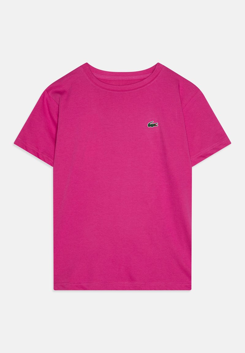T-shirt en coton rose vif avec un col rond et des manches courtes, arborant un petit logo de crocodile brodé vert sur la poitrine gauche.