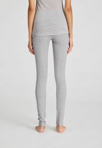Graue, gerippte Leggings aus weichem, dehnbarem Material, mit einer schmalen Passform und glatter Textur. Keine sichtbaren Nähte oder Muster.