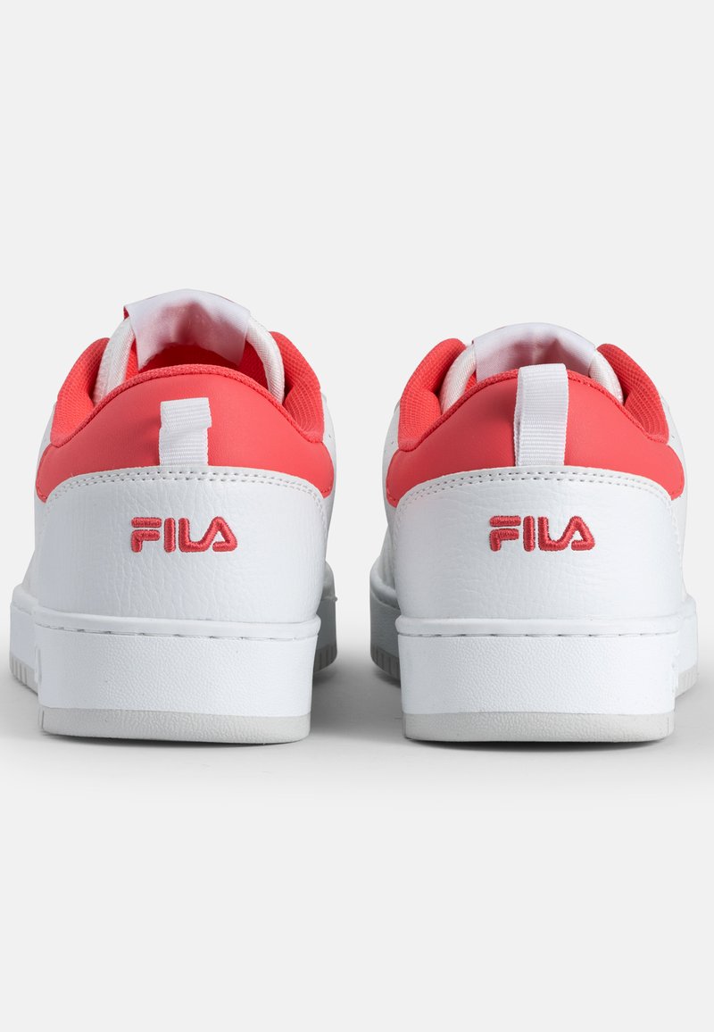 Zapatillas de cuero blanco con acentos en coral. Cuello y lengüeta acolchados, paneles texturizados y suela de goma blanca. El logo "Fila" es rojo en el talón.