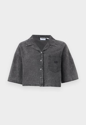 Chemise courte en denim noir délavé avec manches courtes, boutonnée à l'avant, col et poche poitrine sur fond uni.