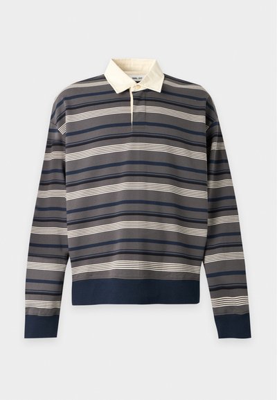 Maillot de rugby à manches longues avec des rayures horizontales bleu marine, gris et blanc et un col blanc sur fond gris clair.