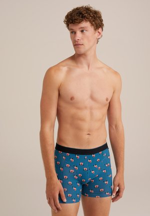 Männliche blaue Boxershorts mit einem schwarzen Bund, versehen mit einem sich wiederholenden Muster aus kleinen roten und weißen Illustrationen. Weicher, dehnbarer Stoff.