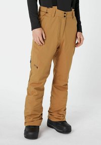 Skibroek in een tan kleur, gemaakt van waterafstotende stof, met verstelbare bretels en een ritszak aan de zijkant.