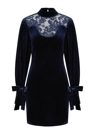Granatowa aksamitna sukienka z koronkowym dekoltem, wysoką szyją i długimi rękawami. Posiada kokardki przy mankietach dla dodatkowego efektu.