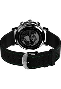 Sangle en textile noire avec des coutures vertes, boîtier en acier inoxydable, cadran noir avec un motif de globe, et une boucle en argent gravée "TIMEX".