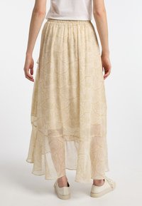 Let stof maxi nederdel med et flydende design, der har et delikat paisley mønster og en elastisk talje. Struktureret, gennemsigtigt stof.