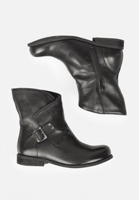 Black leather ankle boots featuring a zip closure, side buckle detail, and a flat rubber sole with a slightly raised heel.