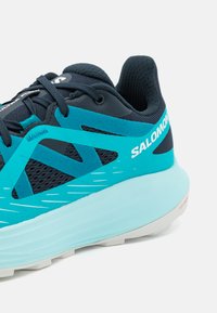 Aquamarinfarbene Laufschuhe mit Mesheinsatz, Wildlederakzenten und weißem Logo. Verfügt über eine weiche, strukturierte Sohle und ein leichtes Design.