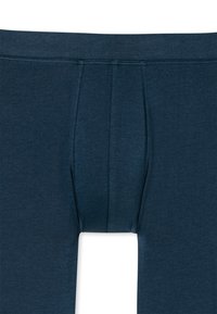 Pánské boxerky námořnické modré barvy s elastickým pasem, tvarovanou kapsou a plochými švy; vyrobené z měkké, elastické bavlněné směsi.