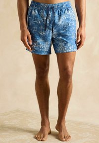 Pantaloni scurți de înot albaștri cu un imprimeu tropical alb, având o talie elastică și șnur. Materialul pare neted și ușor.