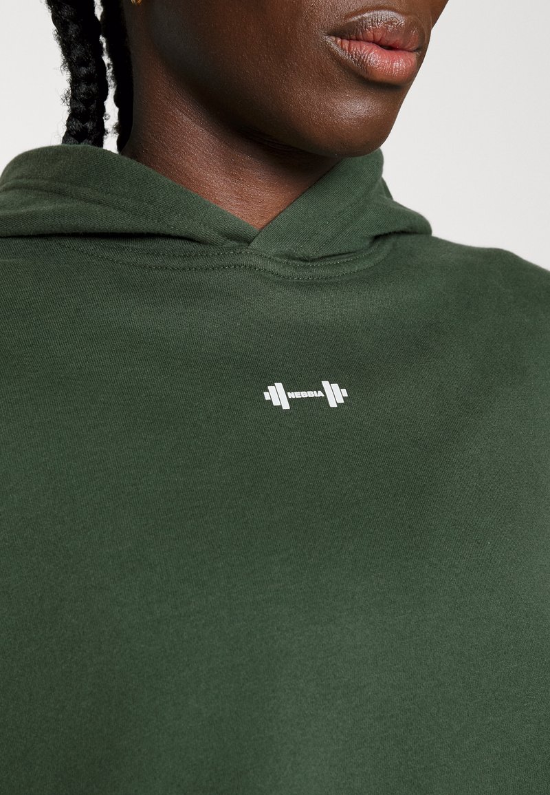 Damen Sweatshirts | Nebbia LOOSE FIT CROP HOODIE ICONIC Kapuzenpullover dark green/dunkelgrün - JR04035 Damen Sweatshirts | Nebbia LOOSE FIT CROP HOODIE ICONIC Kapuzenpullover dark green/dunkelgrün - JR04035