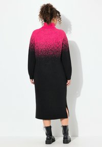 Abito maglione lungo e nero con un gradiente rosa nella parte superiore. Collo alto, maniche lunghe e spacchi laterali. Realizzato in materiale a maglia testurizzata.