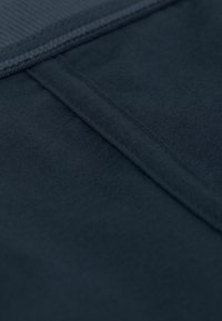 Tmavě modravá tkanina s hladkým povrchem, se jemným vzorem a čistým švem podél okrajů. Žádné viditelné kovové prvky ani akcenty.