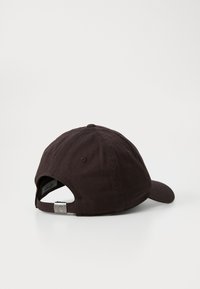 Gorra de béisbol de algodón negro con visera curva, correa ajustable y herrajes metálicos. Textura suave con acentos de costura en la corona.