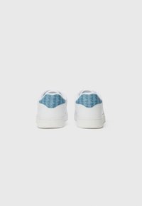 Sneakers bianchi con un pannello posteriore azzurro chiaro testurizzato caratterizzato da un motivo geometrico, lacci piatti e suola in gomma.