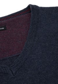 Granatowy sweter z dekoltem w kształcie V. Żebrowany kołnierz, miękka tekstura i bordowe wykończenie wewnętrzne. Metka widoczna przy dekolcie.