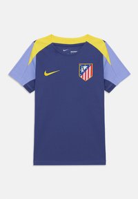 Mørkeblå kortermet trøye med gule og lyseblå detaljer, som har Nike-logo og Atlético Madrid-emblem på fronten.