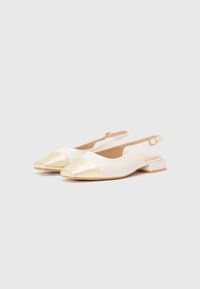 Vita slingback-skor med rund tå, guldmetallisk topp, låg blockklack och justerbar ankelrem. Slät lädermaterial.