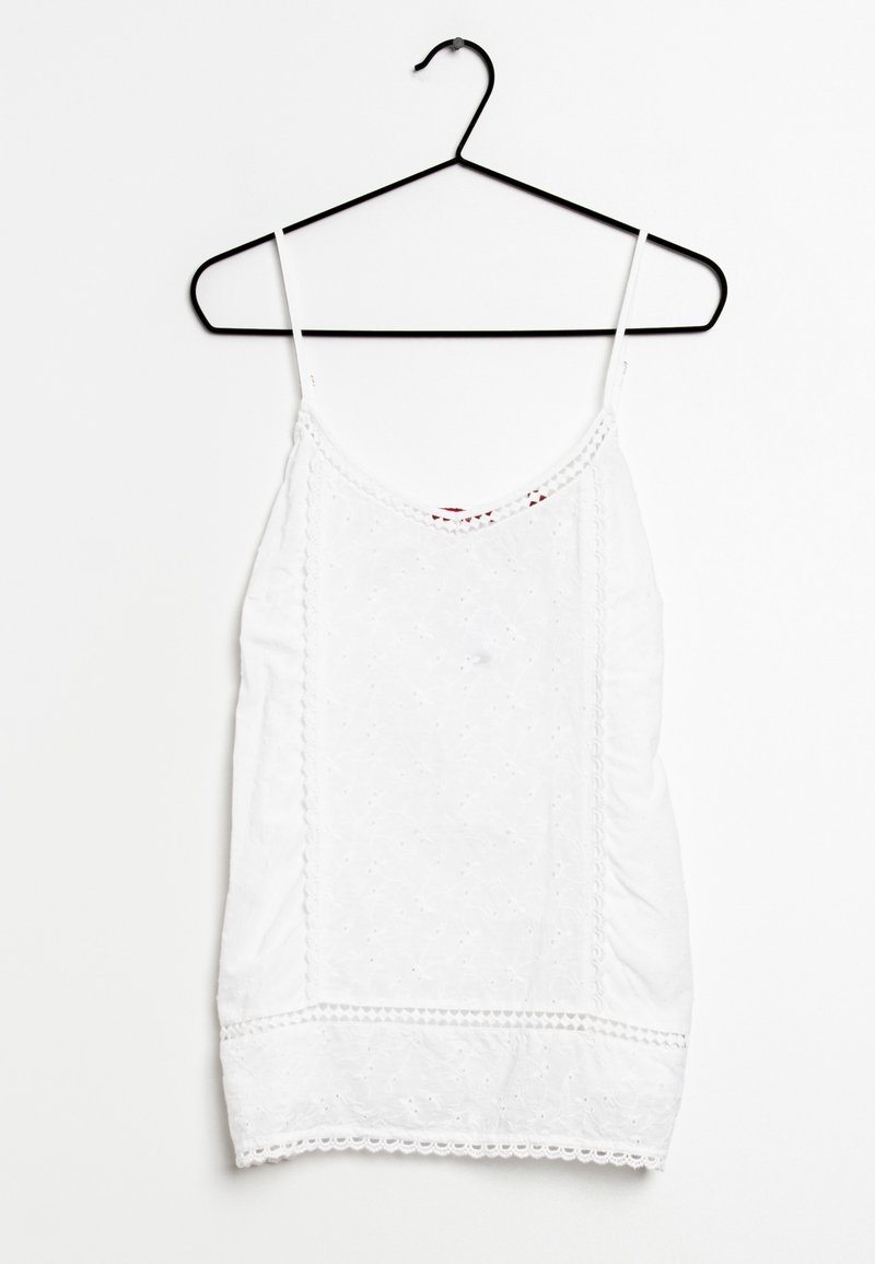 Bílý top bez rukávů na černém ramínku, zdobený vyšívanými vzory, krajkovým lemem na spodním okraji a nastavitelnými ramínky. Měkká textilie.