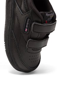 Sorte lærsk sneaker med borrelåsremmer, teksturert såle, perforert tå og Reebok-merke. Rund form med kontrasterende sømdetaljer.