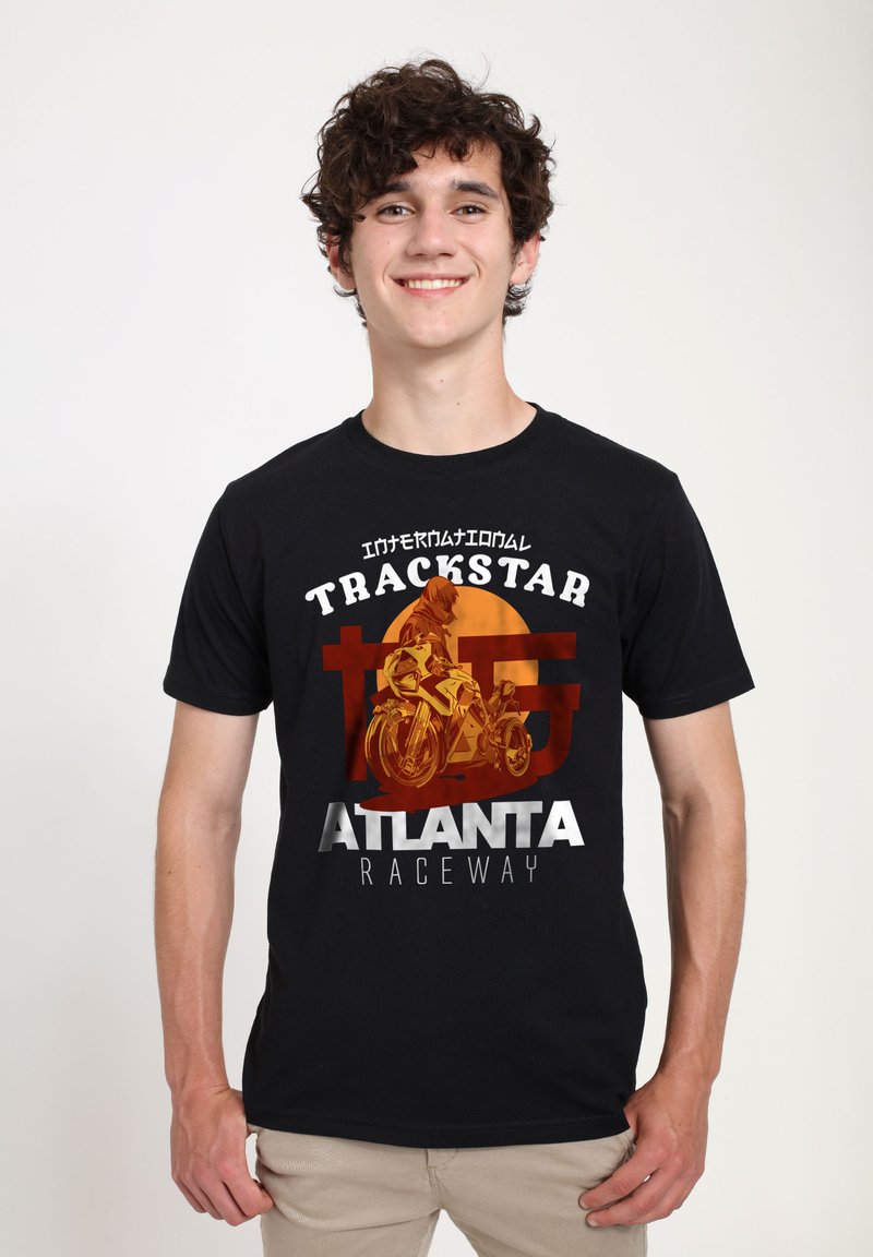 Camiseta de algodón negra con un estampado gráfico de una motocicleta y texto: "INTERNATIONAL TRACKSTAR ATLANTA RACEWAY" en naranja y blanco.