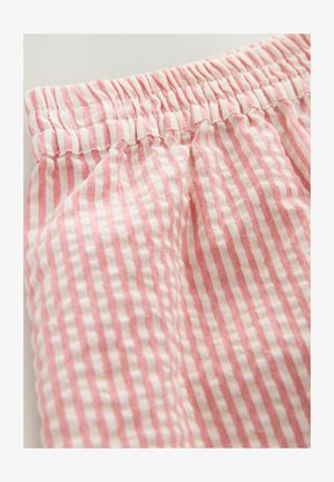 Tkanina s ružičastim i bijelim prugama s elastiziranim pojasom, koja se odlikuje mekanom teksturom i vertikalnim linijama. Prikaz blizu materijala.