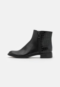 Botte cheville en cuir noir avec un bout pointu, un panneau texturé à motif crocodile à l'arrière, une fermeture éclair sur le côté et un petit talon solide.