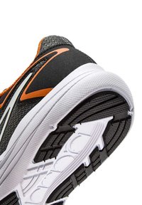 Scarpa sportiva nera con tomaia in mesh e dettagli arancioni, dotata di suola in gomma bianca testurizzata con battistrada a motivo per una migliore trazione.