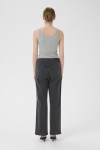 Gray tank top paired with high-waisted, wide-leg black jeans. Smooth fabric, subtle stitching, and classic patch pockets.