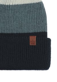Czapka robiona na drutach z teksturą żebrową; posiada gradient jasnoszarego, niebieskiego i ciemnogranatowego koloru; zawiera brązową skórzaną metkę.