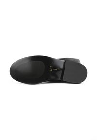 Sole di scarpa nera con finitura liscia, caratterizzata da scanalature orizzontali per una migliore aderenza e marcature della taglia in rilievo. Tacco testurizzato e accenti laterali visibili.