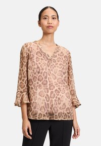 Blusa in stampa leopardata marrone chiaro con scollo a V e maniche a tre quarti. Tessuto morbido e fluido con una leggera texture e polsini arricciati.