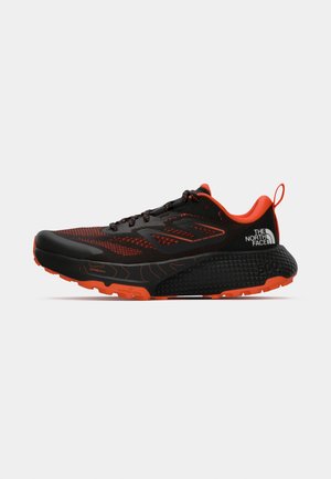 Zapatilla de correr negra con acentos rojos; parte superior de malla transpirable, suela texturizada y cuello acolchado; cuenta con logo y puntera de goma.