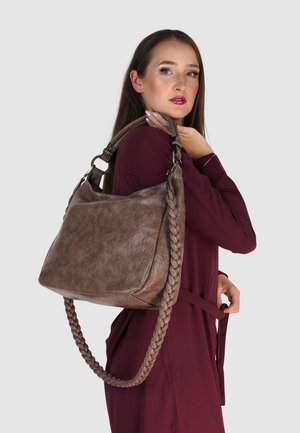 Braune, strukturierte Handtasche mit geflochtenem Tragegurt und silbernem Zubehör, die ein weiches Hobo-Design aufweist. Über der Schulter getragen vor einem neutralen Hintergrund.