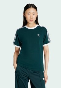 Green short-sleeve t-shirt with white collar and cuffs, featuring three white stripes on shoulders and a small Adidas logo on chest.