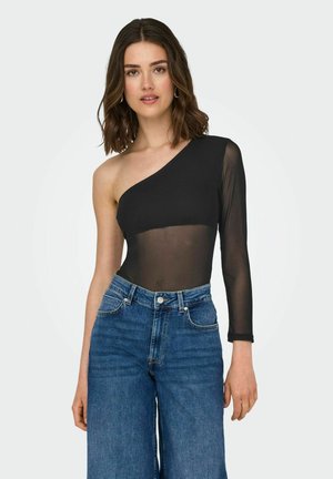 Czarny body na jedno ramię z przezroczystym długim rękawem, zestawione z wysokim stanem niebieskimi dżinsami typu wide-leg. Minimalistyczny design, gładka tekstura.