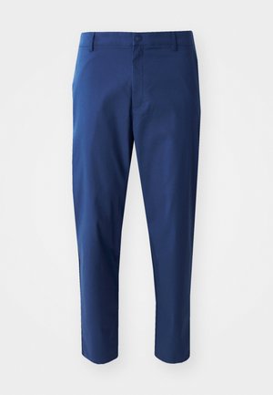 Navy blue chinos with a smooth texture, a buttoned waistband, and side pockets, featuring a tailored fit and cropped length.