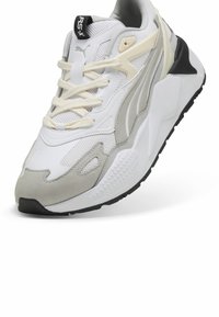 Bílé tenisky s vrchním materiálem ze síťoviny a šedými semišovými akcenty, texturovanou mezipodešví a černou gumovou podrážkou; krémové tkaničky a logo.