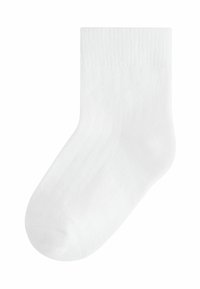 Chaussette en coton blanc avec une texture côtelée, de couleur unie, de longueur mi-mollet et dotée d'un design à orteil arrondi. Simple et légère.