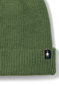 Grüner gestrickter Beanie mit gerippter Textur, ausgestattet mit einem umgeschlagenen Bündchen und einem kleinen schwarzen Etikett mit Graf design und farbigen Streifen.