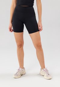 Schwarze, hoch taillierte Radlerhosen aus dehnbarem Material mit einer glatten Textur und ohne sichtbare Muster oder Akzente.