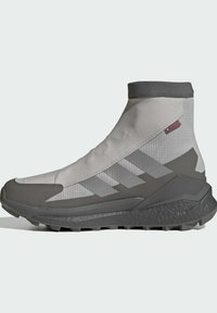 Grå högklättrade vandringsskor med texturerad ovandel, kontrasterande mörkare grå detaljer och en robust sula för grepp.