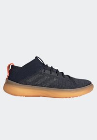 Sneakers blu scuro con tomaia in maglia strutturata, dettaglio arancione sul tallone e suola in gomma traslucida. Presentano lacci piatti e accenti a righe.